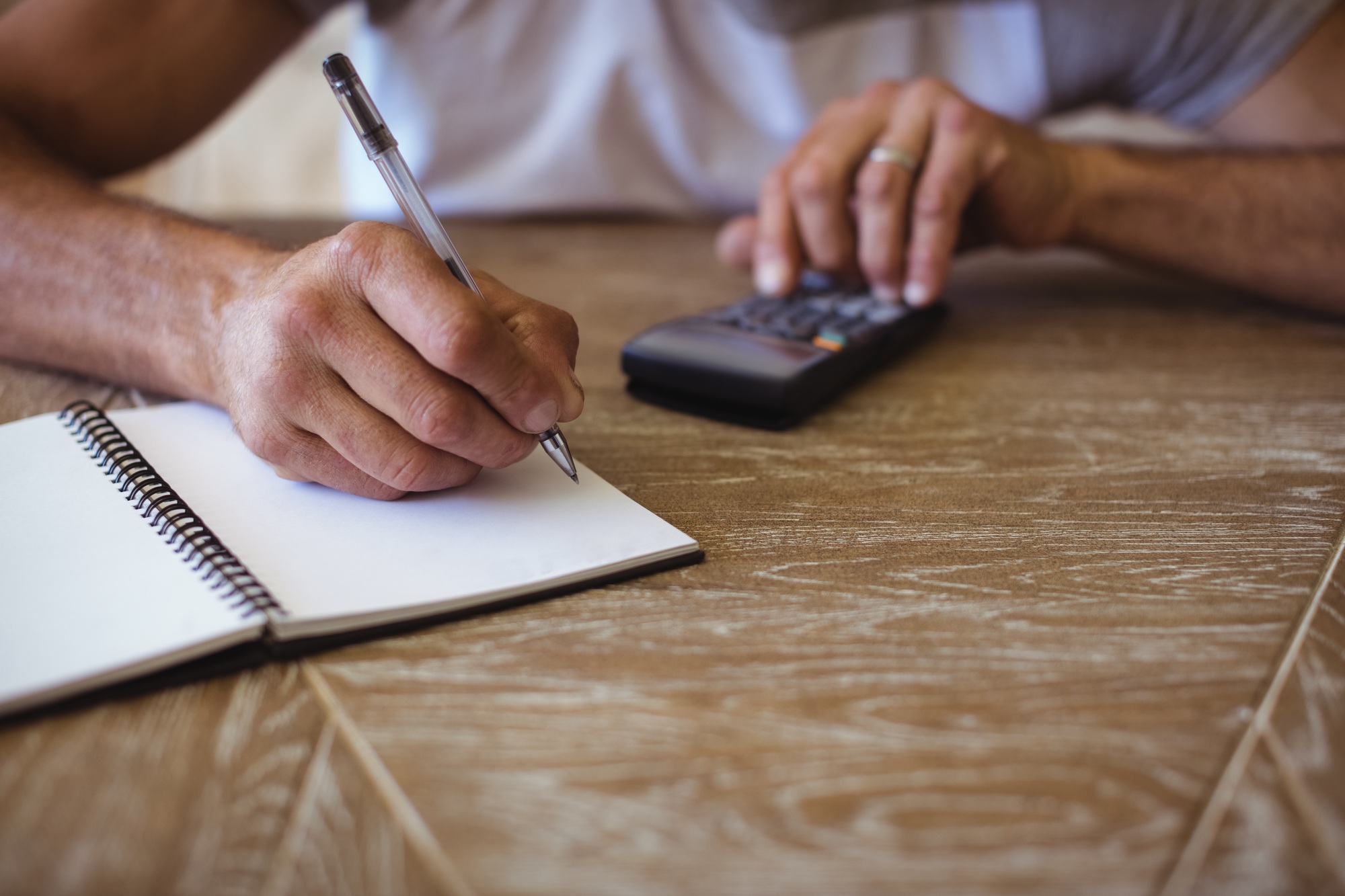 Man using calculator to calculate expenses